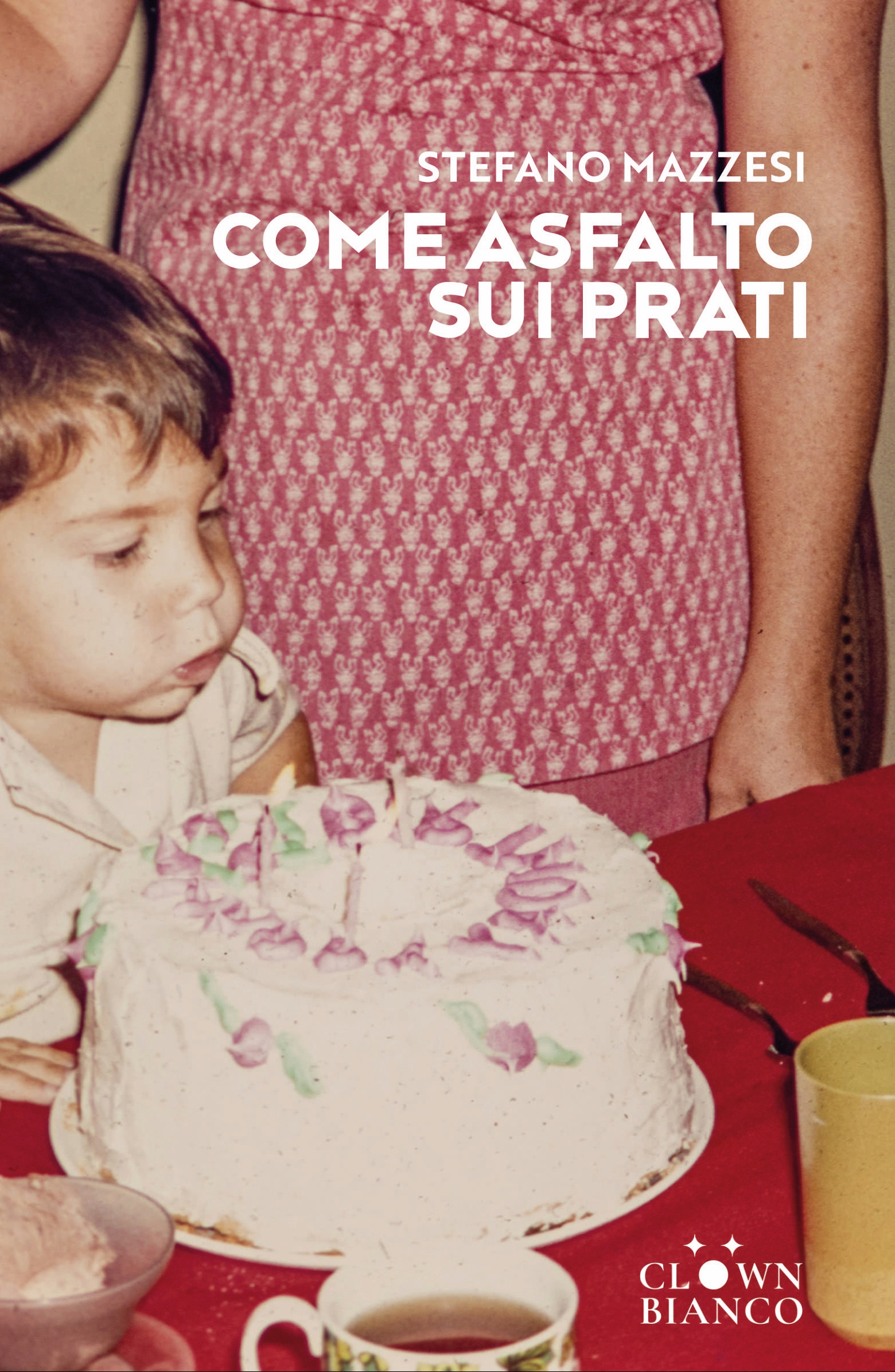 Un bambino soffia sulle candeline di una torta di compleanno. La foto non è attuale, risale ai primi anni Ottanta. Dietro di lui si intravede la madre.
